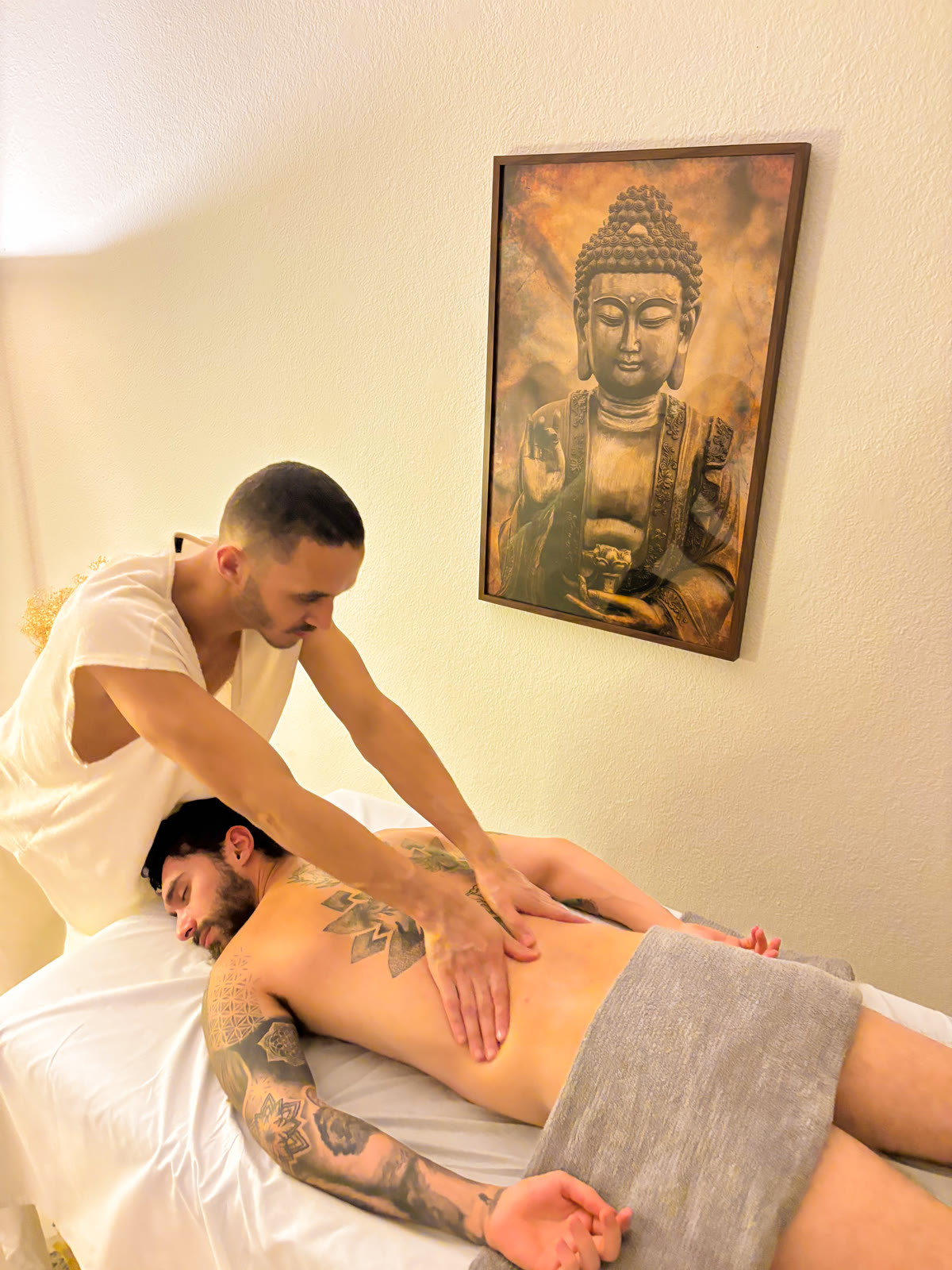 Gaspar fazendo massagem com as duas mãos nas costas de um cliente